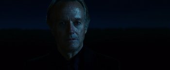 Movie still from “Ghost Rider” (2007), directed by Mark Steven Johnson – An older man in a black suit stares at the camera; Close Up shot, Low angle