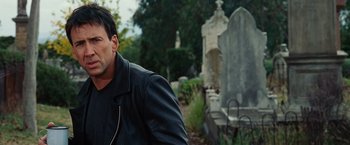 Movie still from “Ghost Rider” (2007), directed by Mark Steven Johnson – A man wearing a black jacket standing in front of a grave; Close Up shot, Over the shoulder angle
