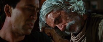Movie still from “Ghost Rider” (2007), directed by Mark Steven Johnson – An older man with long gray hair and a beard; Close Up shot, Over the shoulder angle