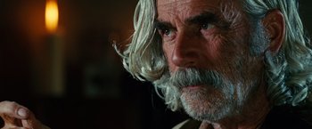 Movie still from “Ghost Rider” (2007), directed by Mark Steven Johnson – An older man with long white hair and a beard; Close Up shot, Over the shoulder angle