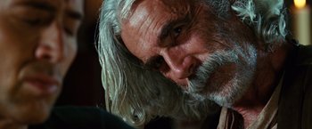 Movie still from “Ghost Rider” (2007), directed by Mark Steven Johnson – An older man with long white hair and a beard; Close Up shot, Over the shoulder angle