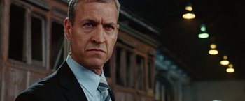 Movie still from “Ghost Rider” (2007), directed by Mark Steven Johnson – An older man in a suit and tie looking at the camera; Close Up shot, Low angle