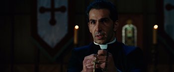 Movie still from “Ghost Rider” (2007), directed by Mark Steven Johnson – A man in a priest's outfit holding a rosary; Close Up shot, Low angle