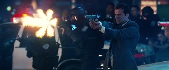 Movie still from “Ghost Rider” (2007), directed by Mark Steven Johnson – A man holding a gun in front of a group of people; Medium shot, Low angle