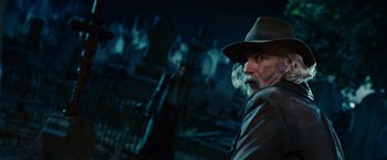 Movie still from “Ghost Rider” (2007), directed by Mark Steven Johnson – An older man wearing a hat and a leather jacket; Close Up shot, Over the shoulder angle