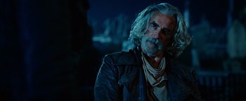 Movie still from “Ghost Rider” (2007), directed by Mark Steven Johnson – An older man with long white hair and a beard; Close Up shot, Over the shoulder angle