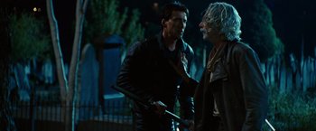 Movie still from “Ghost Rider” (2007), directed by Mark Steven Johnson – A man holding a baseball bat in front of another man; Medium shot, Over the shoulder angle