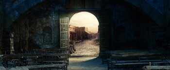 Movie still from “Ghost Rider” (2007), directed by Mark Steven Johnson – An open door leading to a courtyard with benches; Extreme Wide shot, Low angle