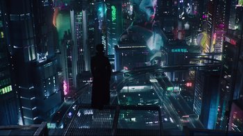 Movie still from “Ghost in the Shell” (2017), directed by Rupert Sanders – A man standing on top of a skyscraper looking at a city; Extreme Wide shot, Overhead angle