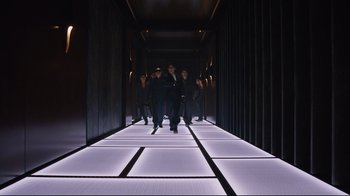 Movie still from “Ghost in the Shell” (2017), directed by Rupert Sanders – A group of people walking down a long hallway; Wide shot, Low angle