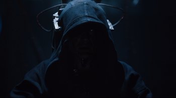 Movie still from “Ghost in the Shell” (2017), directed by Rupert Sanders – A man in a hooded jacket and a helmet; Close Up shot, Over the shoulder angle