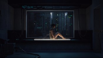 Movie still from “Ghost in the Shell” (2017), directed by Rupert Sanders – A woman sitting in front of a window at night; Wide shot, High angle