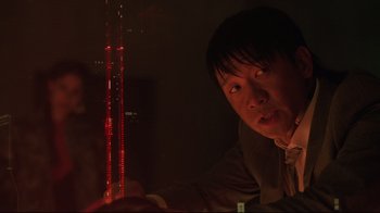 Movie still from “Ghost in the Shell” (2017), directed by Rupert Sanders – A man is looking at a tower with red lights; Close Up shot, Low angle