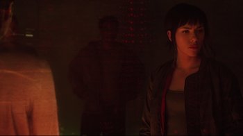 Movie still from “Ghost in the Shell” (2017), directed by Rupert Sanders – A woman standing next to a man in a dark room; Medium shot, Over the shoulder angle
