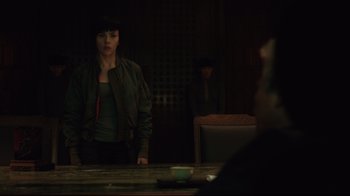 Movie still from “Ghost in the Shell” (2017), directed by Rupert Sanders – A woman standing in front of a man in front of a table; Medium shot, Over the shoulder angle