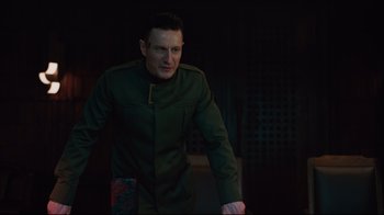 Movie still from “Ghost in the Shell” (2017), directed by Rupert Sanders – A man in a green jacket standing in a dark room; Medium shot, Over the shoulder angle