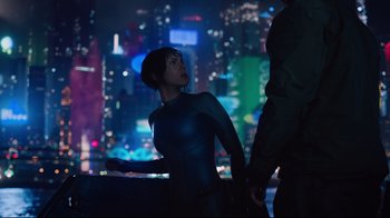Movie still from “Ghost in the Shell” (2017), directed by Rupert Sanders – A woman standing next to a man on a city street at night; Medium shot, Over the shoulder angle