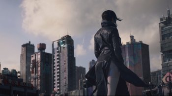 Movie still from “Ghost in the Shell” (2017), directed by Rupert Sanders – A woman standing in front of a tall building; Wide shot, Low angle