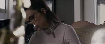 Movie still from “Incident in a Ghostland” (2018), directed by Pascal Laugier – A woman wearing glasses and holding a pen in her mouth; Close Up shot, Over the shoulder angle