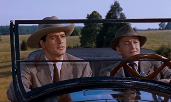 Movie still from “Giant” (1956), directed by George Stevens – A couple of men sitting in the back seat of a car; Medium shot, Low angle
