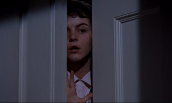 Movie still from “Giant” (1956), directed by George Stevens – A man in a white dress shirt and tie looking through a door; Close Up shot, Low angle