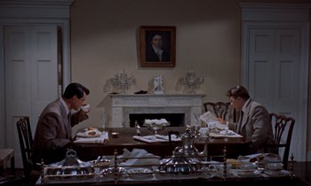 Movie still from “Giant” (1956), directed by George Stevens – Two people sitting at a dining room table; Wide shot, High angle
