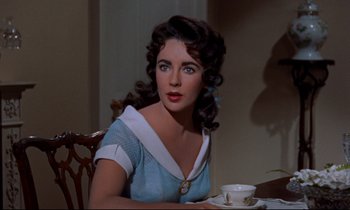 Movie still from “Giant” (1956), directed by George Stevens – A woman sitting at a table with a cup of coffee; Close Up shot, Over the shoulder angle