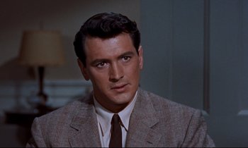 Movie still from “Giant” (1956), directed by George Stevens – A person wearing a suit and tie; Close Up shot, Over the shoulder angle