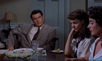 Movie still from “Giant” (1956), directed by George Stevens – A man and a woman sitting at a dinner table; Medium shot, Over the shoulder angle