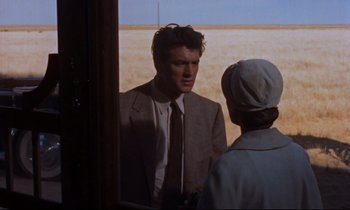 Movie still from “Giant” (1956), directed by George Stevens – A man in a suit talking to a woman in an apron; Medium shot, Over the shoulder angle