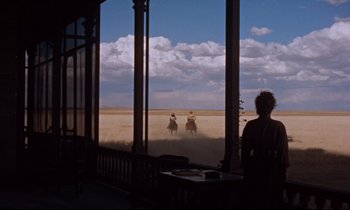 Movie still from “Giant” (1956), directed by George Stevens – Two people on horseback riding through the desert; Extreme Wide shot, Low angle