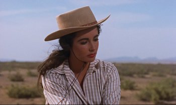 Movie still from “Giant” (1956), directed by George Stevens – A woman wearing a cowboy hat in the middle of the desert; Close Up shot, Over the shoulder angle
