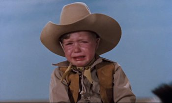 Movie still from “Giant” (1956), directed by George Stevens – A little boy wearing a cowboy hat crying; Medium shot, Low angle