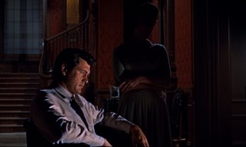 Movie still from “Giant” (1956), directed by George Stevens – A man and a woman standing in a dark room; Medium shot, Low angle