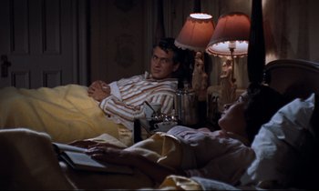 Movie still from “Giant” (1956), directed by George Stevens – A man and a woman sitting on a bed next to each other; Medium shot, High angle