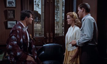 Movie still from “Giant” (1956), directed by George Stevens – A man and two women talking to each other in a room; Medium shot, Over the shoulder angle