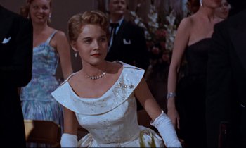Movie still from “Giant” (1956), directed by George Stevens – A woman wearing a white dress and a white glove; Medium shot, Low angle
