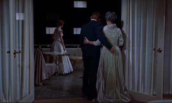 Movie still from “Giant” (1956), directed by George Stevens – A man and a woman dressed in formal wear; Wide shot, Over the shoulder angle
