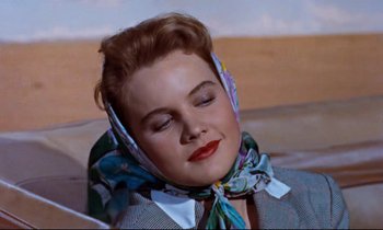 Movie still from “Giant” (1956), directed by George Stevens – A woman with red lipstick wearing a neck scarf; Close Up shot, High angle