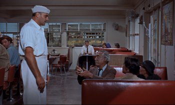 Movie still from “Giant” (1956), directed by George Stevens – Two men and a woman sitting in a restaurant; Wide shot, Over the shoulder angle