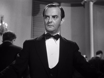 Movie still from “Gilda” (1946), directed by Charles Vidor – A man in a suit and bow tie; Close Up shot, Low angle