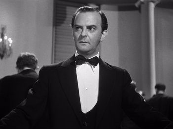 Movie still from “Gilda” (1946), directed by Charles Vidor – A man in a suit and bow tie; Close Up shot, Low angle