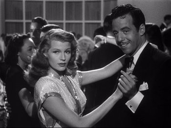 Movie still from “Gilda” (1946), directed by Charles Vidor – A man and a woman are posing for a picture; Medium shot, Low angle