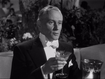 Movie still from “Gilda” (1946), directed by Charles Vidor – An older man in a tuxedo holding a wine glass; Close Up shot, Low angle