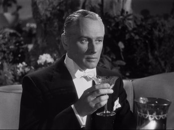Movie still from “Gilda” (1946), directed by Charles Vidor – A man in a tuxedo holding a glass of wine; Close Up shot, Low angle