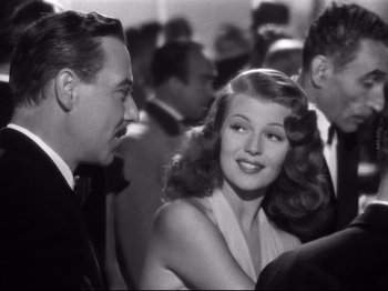 Movie still from “Gilda” (1946), directed by Charles Vidor – A man and a woman are smiling at each other; Close Up shot, Over the shoulder angle