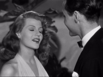 Movie still from “Gilda” (1946), directed by Charles Vidor – A man and a woman smiling at each other; Close Up shot, Over the shoulder angle