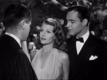 Movie still from “Gilda” (1946), directed by Charles Vidor – Two men and a woman standing next to each other in front of trees; Medium shot, Over the shoulder angle