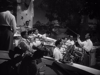 Movie still from “Gilda” (1946), directed by Charles Vidor – A black and white photo of a band performing; Wide shot, High angle