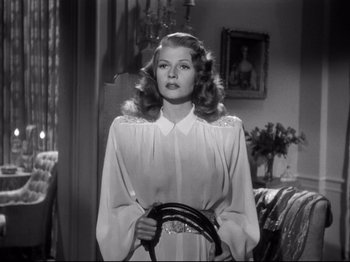 Movie still from “Gilda” (1946), directed by Charles Vidor – A black and white photo of a woman holding a steering wheel; Medium shot, Low angle